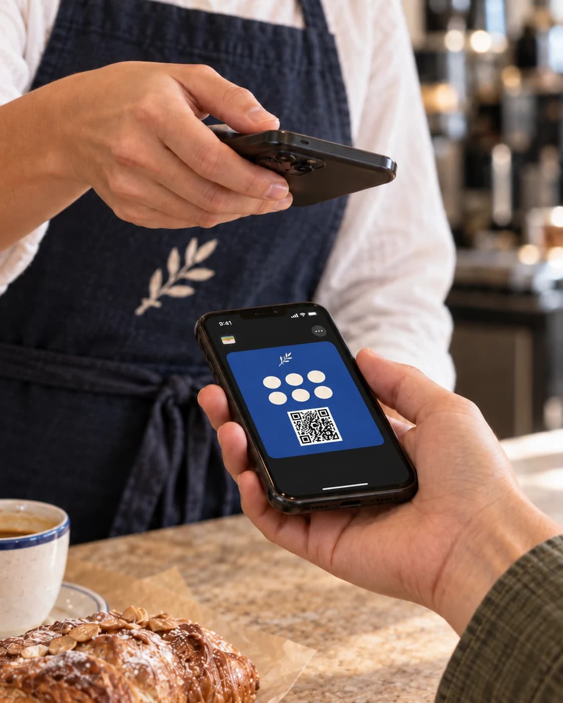 Una barista escanea la tarjeta de fidelización del móvil de un cliente